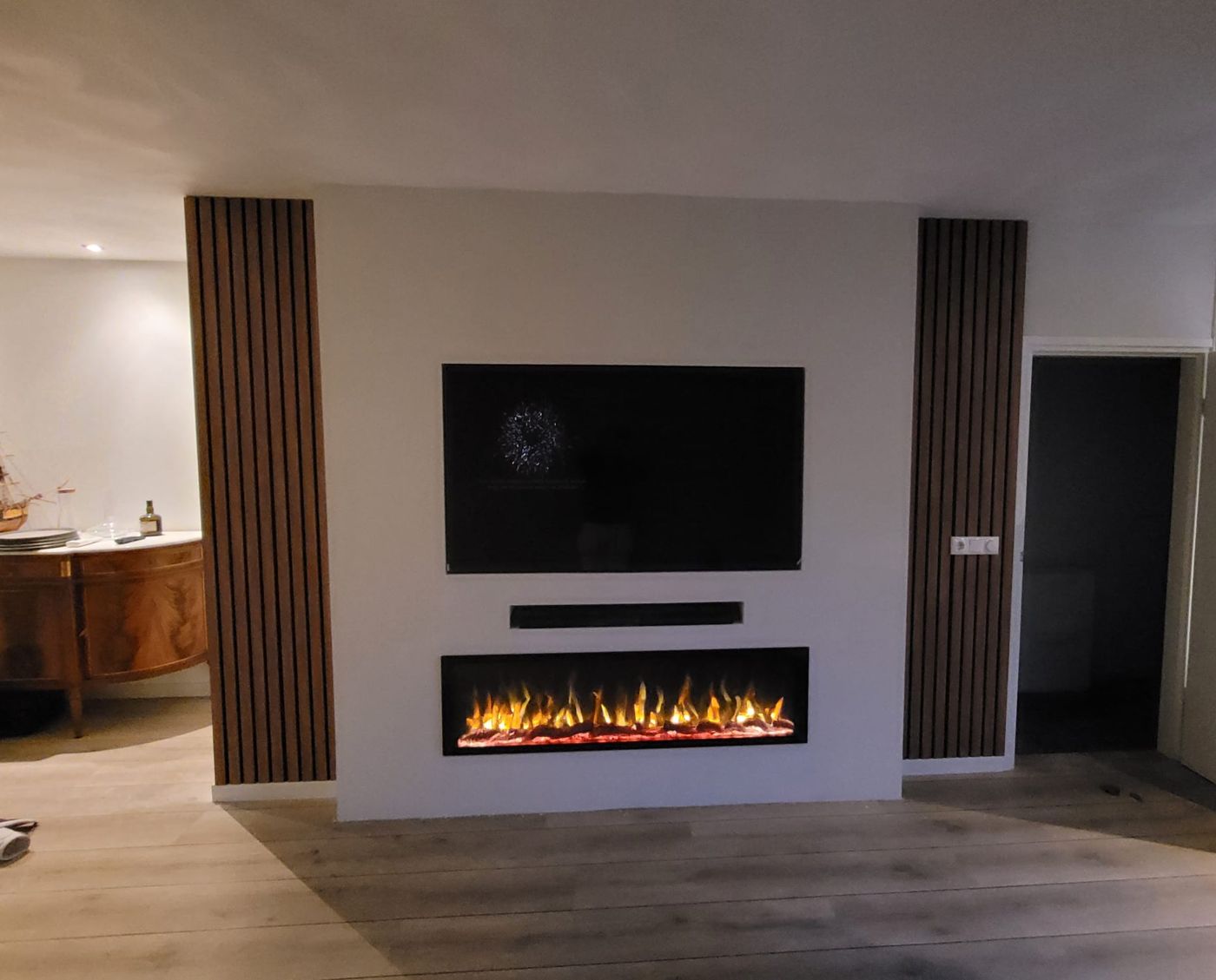 Witte tv-wand met elektrische sfeerhaard, soundbarnis en houten panelen aan beide kanten