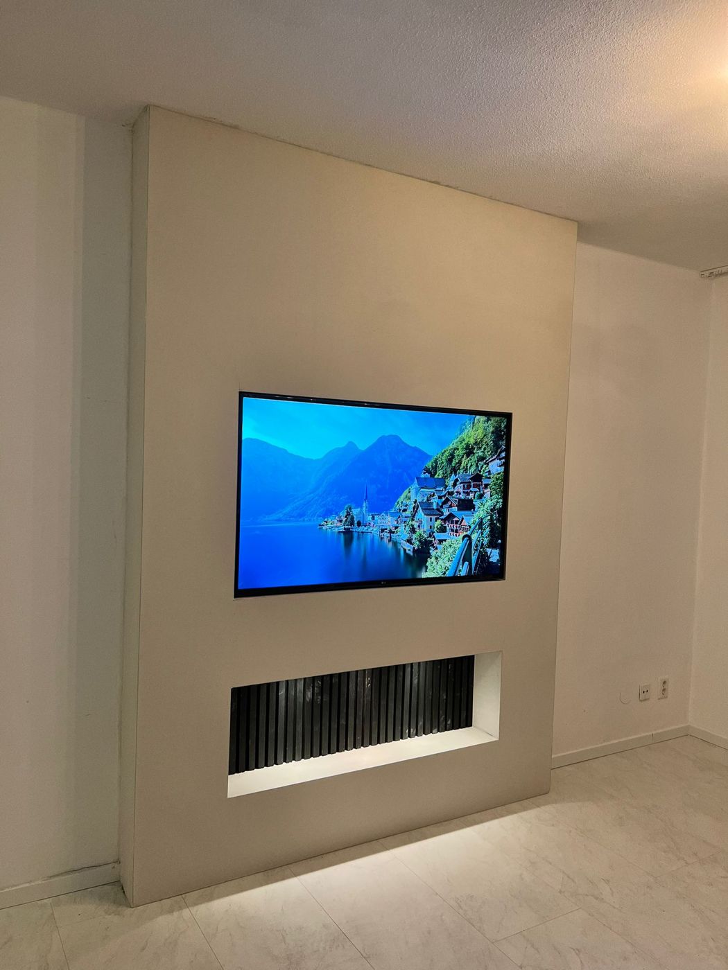 Strakke tv-wand met verzonken tv en een nis met zwarte houten panelen
