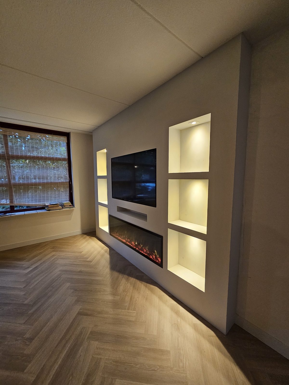 Witte cinewall met sfeerhaard en verlichte nissen in Almere 4 Witte tv-wand in Almere met sfeerhaard en inbouwspots in de nissen