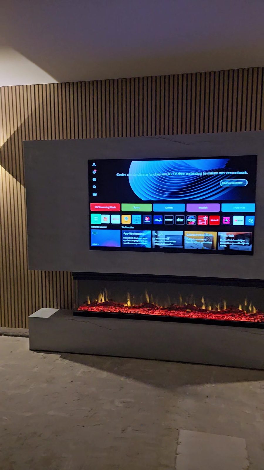 Tv-wand in Utrecht van voren met twee wandlampen op de houten panelen