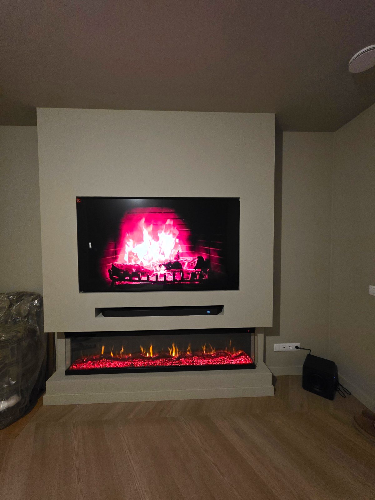 Afgewerkte cinewall met 65 inch tv en 3D-sfeerhaard van 183 cm in Amstelveen 1 Afgewerkte cinewall in Amstelveen met tv, soundbar en sfeerhaard met glas aan drie kanten