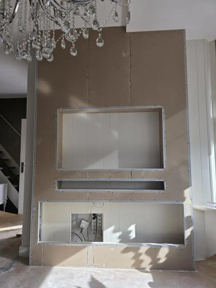 Cinewall in Medemblik: smalle wand van 167 cm met sfeerhaard van 152 cm 1 Cinewall Medemblik tijdens de bouw: gipsplaat met uitsparingen voor tv, soundbar en sfeerhaard