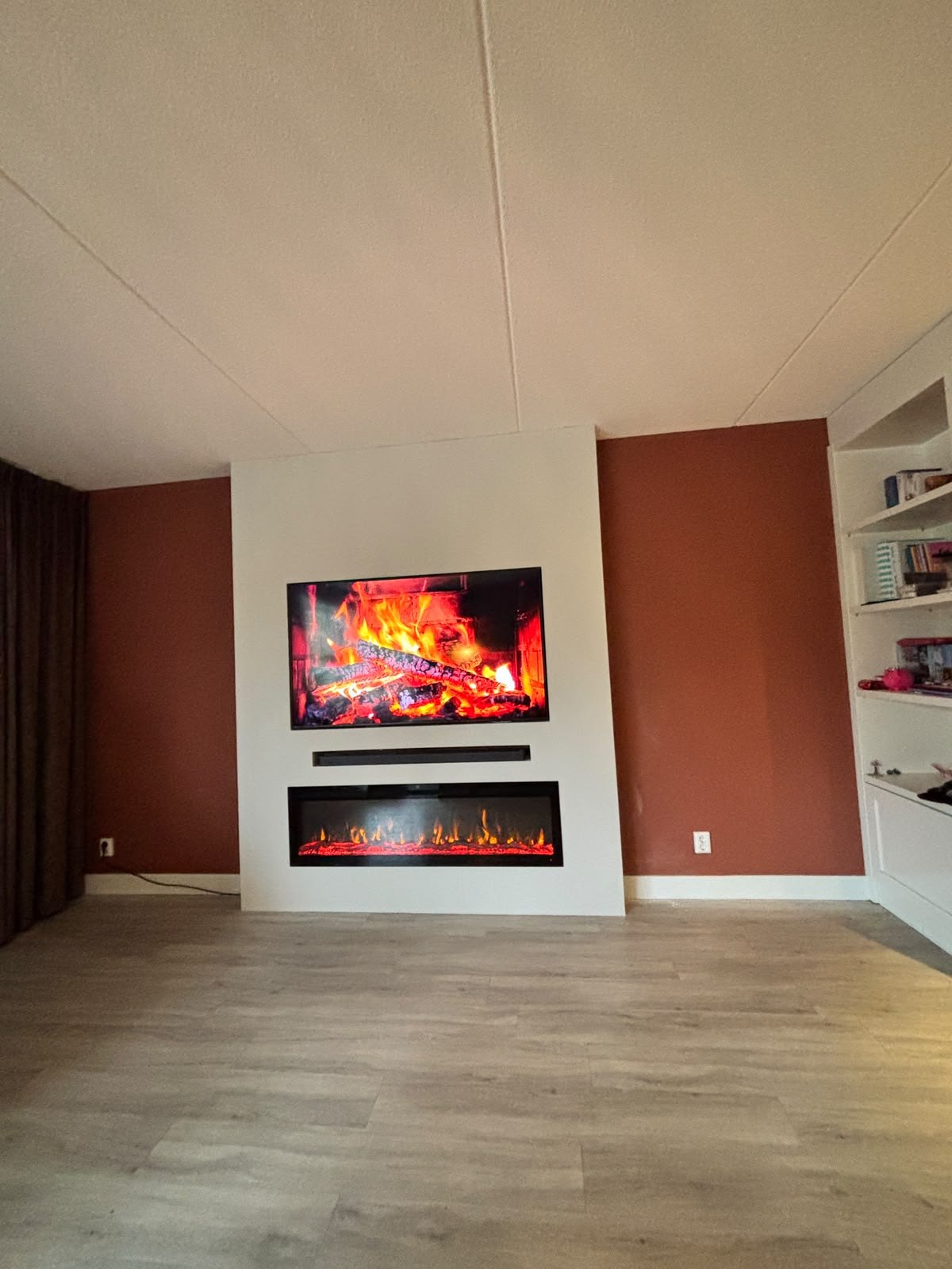 Cinewall met 65 inch tv en sfeerhaard op een wand van 212 cm in Emmeloord 2 Cinewall in Emmeloord schuin van opzij gezien