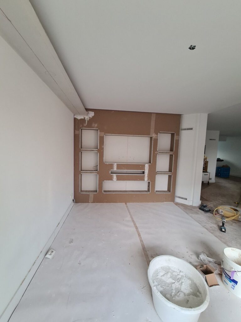 Cinewall met sfeerhaard, verlichte nissen en led-koof in Emmen 4 Cinewall in Emmen tijdens de bouw: gipsplaat met uitsparingen voor tv, soundbar, haard en nissen