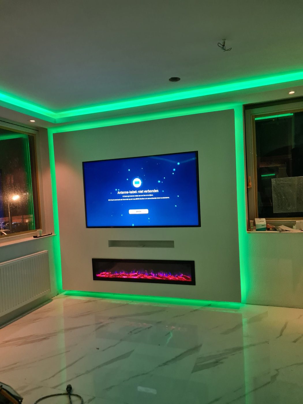 Koof en verlaagd plafond laten maken in Almere 4 Tv-wand met sfeerhaard en koof met indirecte verlichting