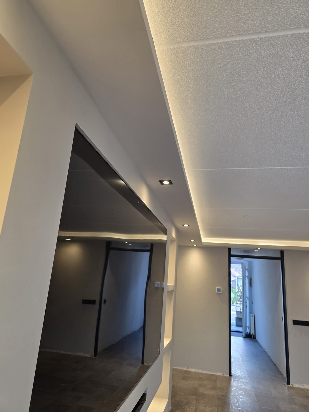 Verlaagd plafond met LED-strip en spots in de gang