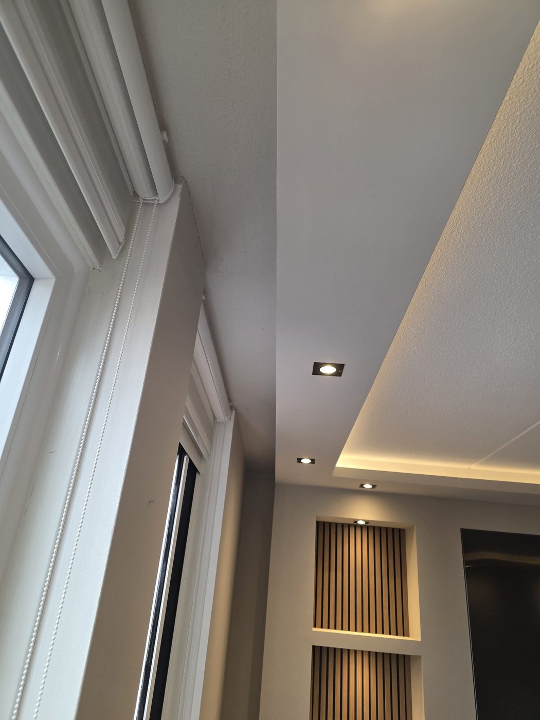 Verlaagd plafond met LED-strip en spots langs het raam