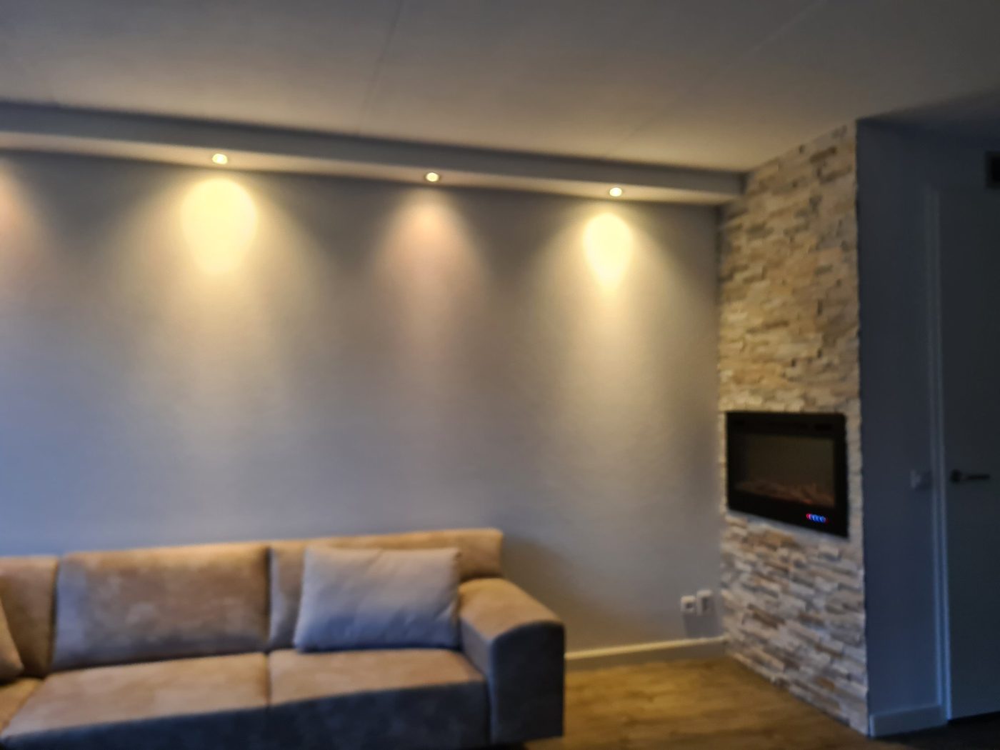 Verlaagd plafond met spots langs de wand in woonkamer