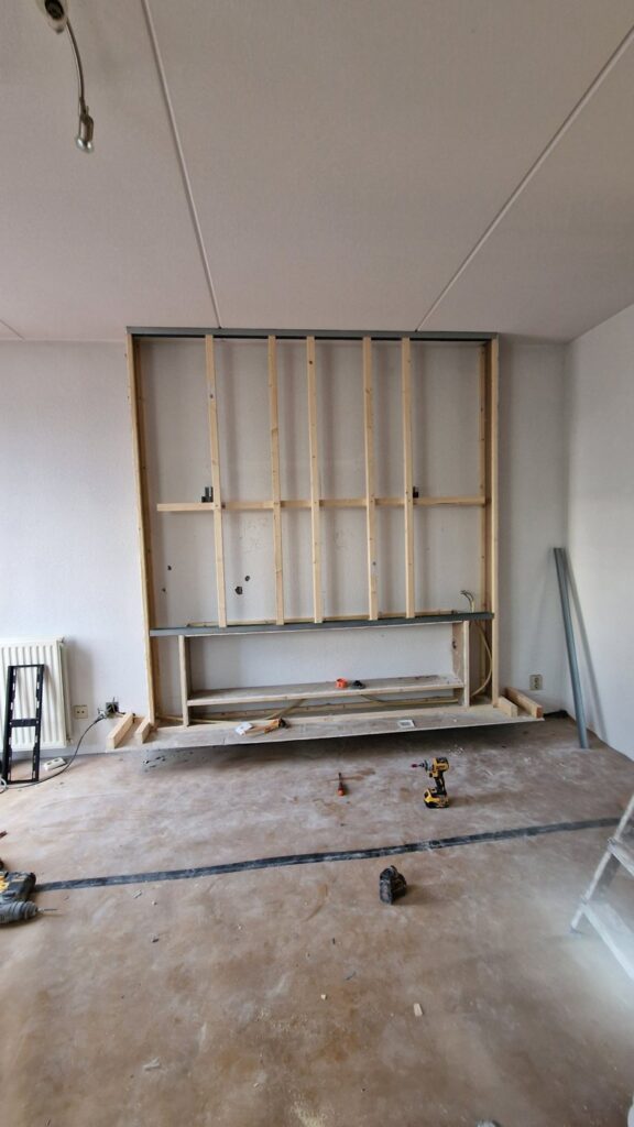 Cinewall voor en na: sfeerhaard en zwevende plank in Lelystad 3 Houten frame van de cinewall met uitsparing voor de sfeerhaard en de zwevende plank