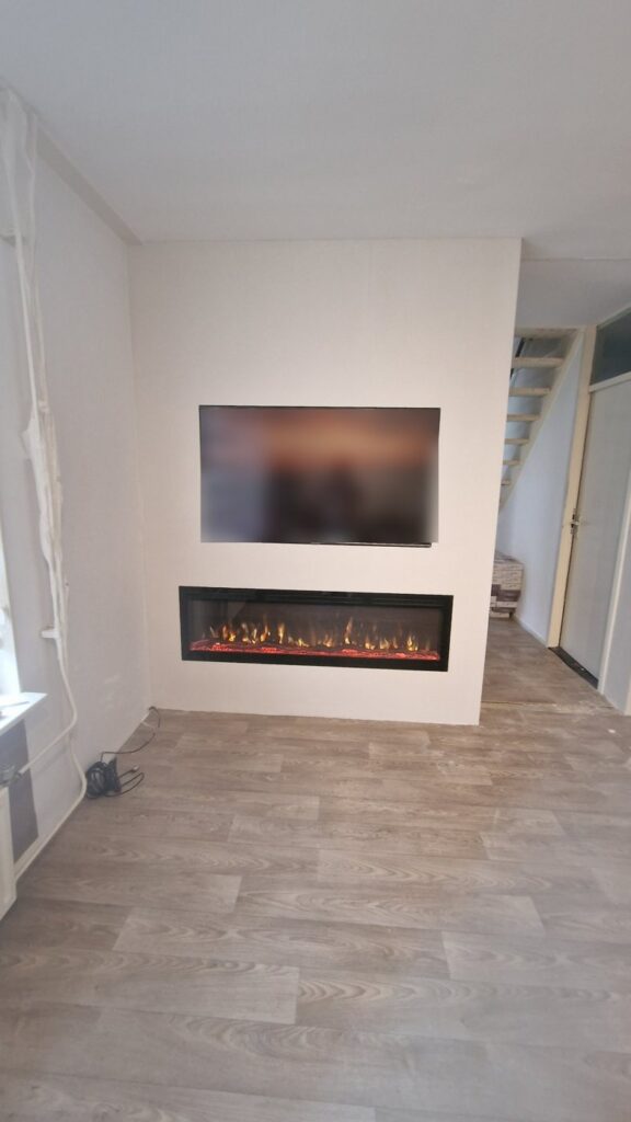 Witte cinewall met tv-nis en brede sfeerhaard in Middelburg 2 Vooraanzicht van de cinewall met sfeerhaard in Middelburg
