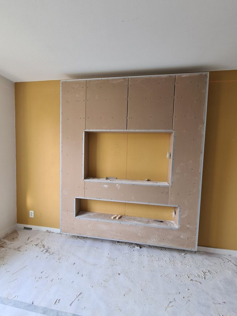 Cinewall in Naaldwijk in aanbouw: gipsplaat met hoekprofielen en uitsparingen voor tv en sfeerhaard