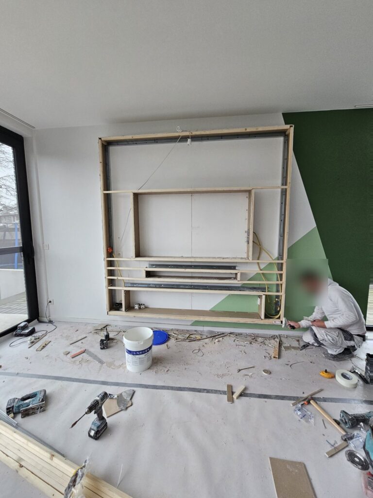 Witte cinewall met extra brede sfeerhaard en kleur-led in Sittard-Geleen 3 Houten frame met metal-stud profielen voor de cinewall in Sittard-Geleen, met uitsparingen voor tv, soundbar en haard
