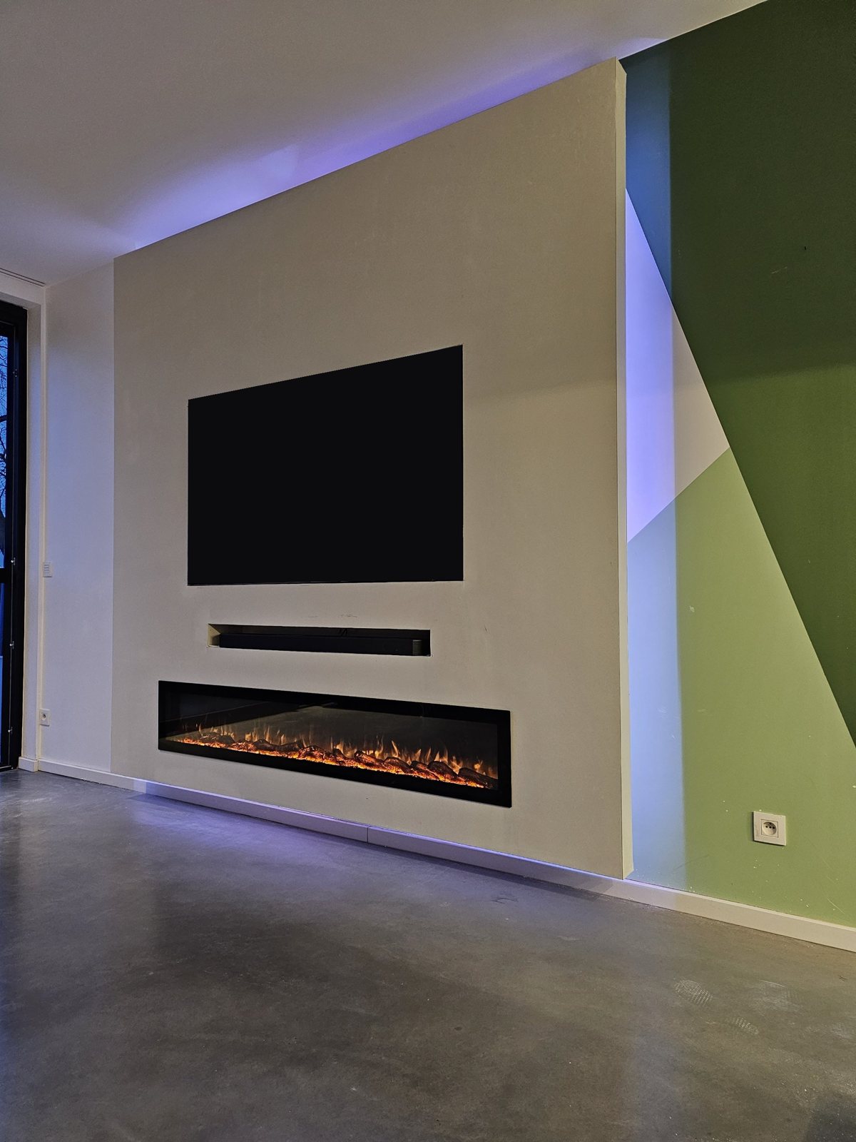 Witte cinewall met tv-nis, soundbar-vak, extra brede sfeerhaard en led-verlichting in Sittard-Geleen