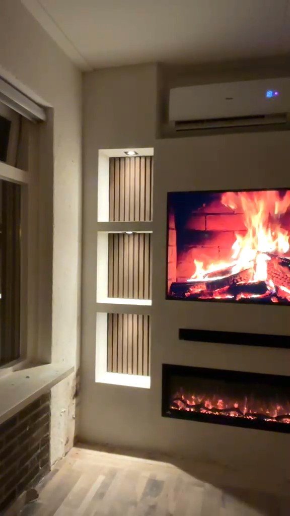 Cinewall met 48 inch tv, sfeerhaard en verlichte nissen in Bellingwolde 1 Cinewall in Bellingwolde met 48 inch tv, sfeerhaard, verlichte nissen met houten panelen en airco in de wand