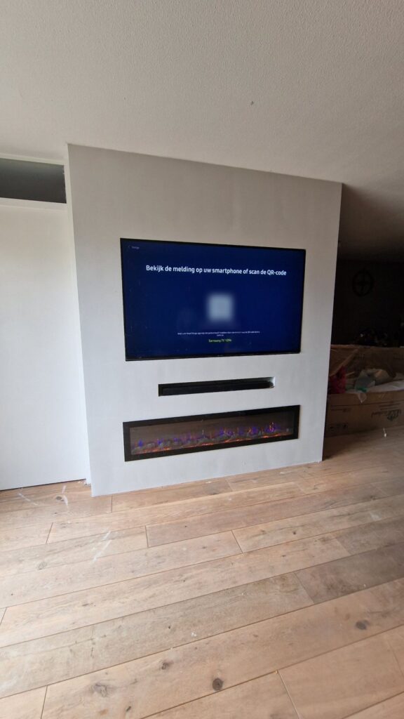 Vrijstaande cinewall met sfeerhaard en soundbar-vak in Sneek 2 Schuin aanzicht van de cinewall met sfeerhaard in Sneek