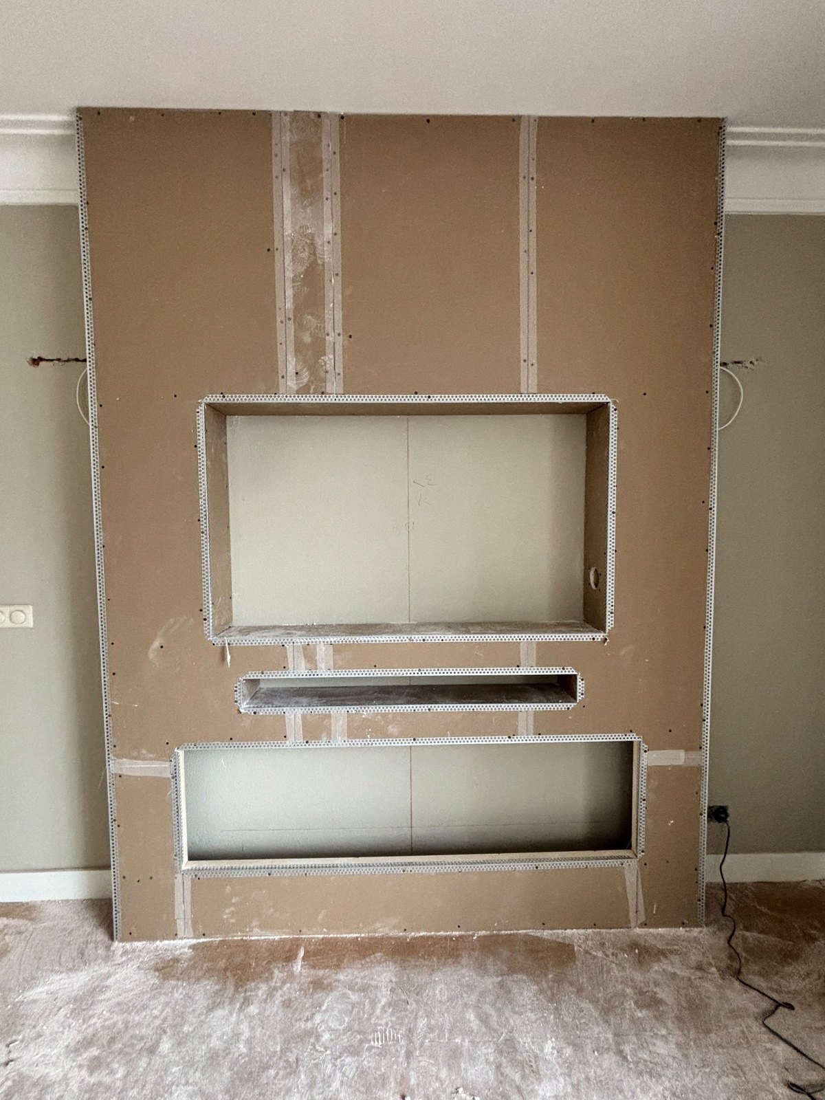 Cinewall met 55 inch tv, sfeerhaard en houten panelen in Veghel 3 Cinewall in Veghel tijdens de bouw, met gipsplaat en uitsparingen voor tv, soundbar en sfeerhaard